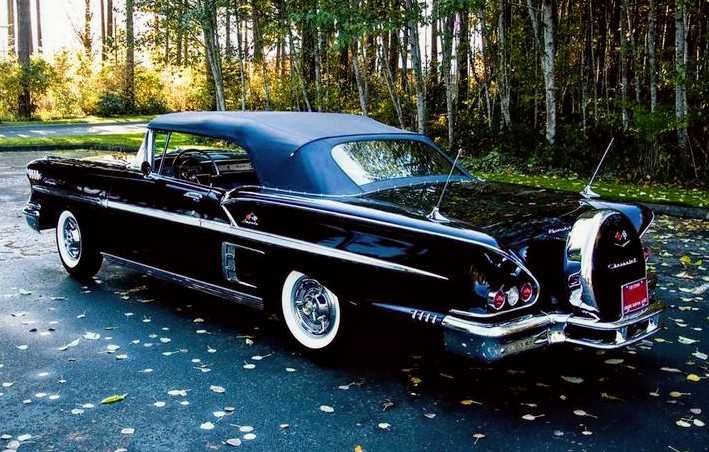 Picture of a classy older car. It's a convertible, all black & shiny. I'm not sure but I think it's a Chevrolet, maybe from the end of the 1950s.